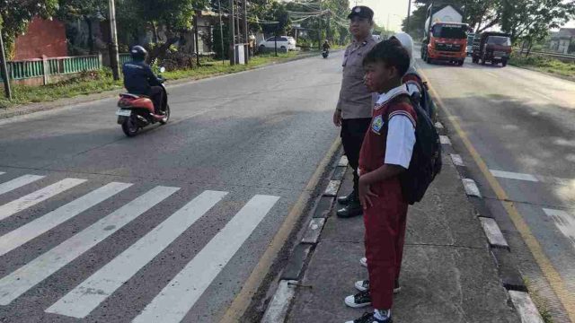 Commander Wish Pagi Polsek Pucuk, Polisi Atur Lalu Lintas dan Bantu Siswa Menyeberang di Depan SDN Waruwetan